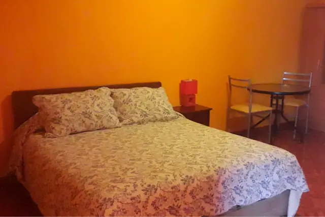 Habitación matrimonial con cama de dos plazas y mesa